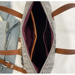Close-up interior view of the woven tote bag featuring burgundy lining and a zipper pocket.