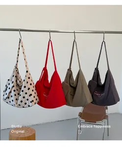 Close-up detail of multi-color large capacity canvas tote bags hanging on a rack