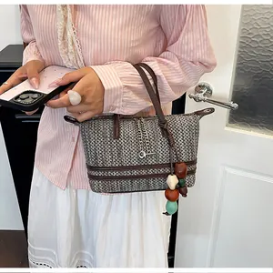 Detailed shot of a stylish woven tote bag with colorful beads and silver chain