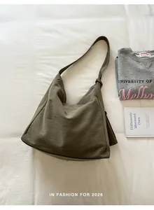 Detailed view of an olive green canvas hobo bag in a relaxed lifestyle flat lay