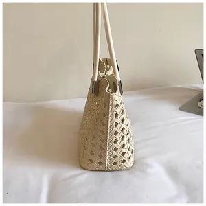 Zijprofiel detail van een crème uitgeholde geweven tote bag voor de zomervakantie