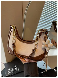 Elegant two-tone hobo bag featuring a gold chain strap and a cute white flower charm detail