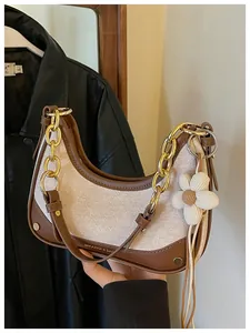 Detail of hobo handbag with color-block canvas and brown faux leather trim