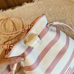 Nahaufnahme einer rosa gestreiften Kordelzug-Beuteltasche mit Marmor-Verschlussdetail