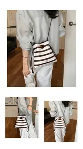 Modische gestreifte Beuteltasche mit Kordelzug, präsentiert an einem weiblichen Model.