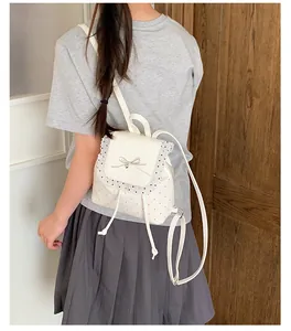 Back view of a white sweet-style lace backpack on a model with bow and polka dots