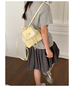 Detail of sweet yellow polka dot backpack with white lace trim and bow for girls
