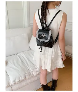 Back view of a sweet black polka dot backpack featuring white lace trim and metal bow