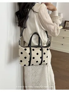 Vista detallada del elegante bolso tote de lona con lunares grandes llevado al hombro