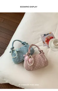Detailed scenario display of stylish polka dot handbags in blue and pink with pearl charms.