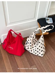 Red and polka dot canvas tote bags displayed on wooden floor