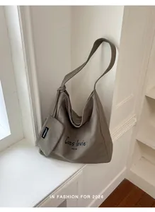 Large taupe canvas hobo shoulder bag featuring 'Cats lovie' print on a white ledge