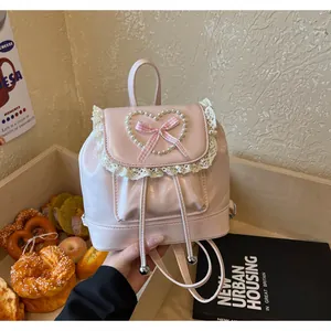 Rosa Mini-Rucksack aus Leder mit Perlenherz, karierter Schleife und Spitzenbesatz-Details.