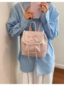 Detailansicht des rosa Mini-Rucksacks mit Perlenherz, Spitze und Karoschleife