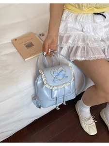 Mini hellblauer Rucksack mit Perlenherz und Spitze in einer Lifestyle-Umgebung