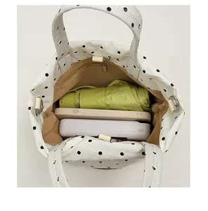 Vue intérieure d'un sac cabas blanc à pois offrant un grand espace pour le quotidien.