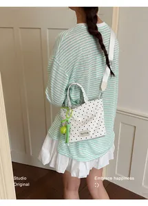 Vue détaillée d'un sac seau à pois blancs avec un charmant porte-clés balle de tennis