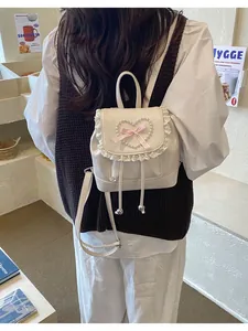 Rückansicht eines Modells mit weißem Mini-Rucksack mit Spitze und Perlenherz-Detail