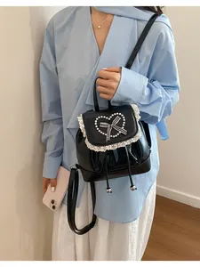 Schwarzer Mini-Rucksack im Vintage-Stil mit Perlenherz und Spitze am Model