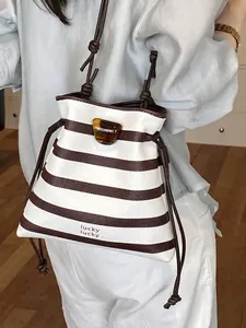 Stilvolle braun-weiß gestreifte Beuteltasche mit Kordelzug und Schildpatt-Akzent.