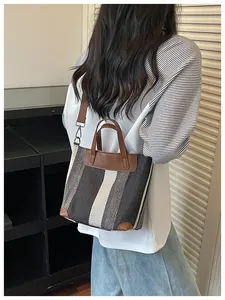 Vue détaillée d'un sac cabas rayé élégant en toile avec des accents de cuir marron