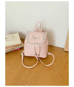 Detailed view of sweet pink girls' backpack featuring lace trim and chic polka dot pattern