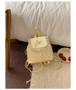 Close-up of a sweet yellow backpack with lace ruffles and strawberry polka dots