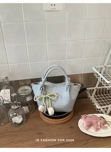 Detailansicht der hellblauen Eimertasche mit Perlenbogen und Tulpenanhängern aus Leder