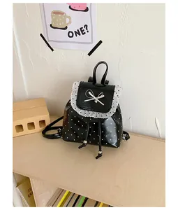 Detail showing the lace trim and polka dot pattern of this cute girl's mini backpack