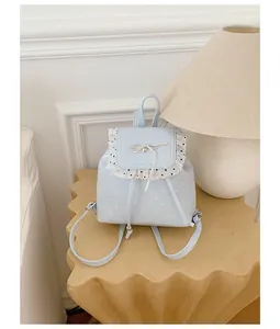 Sweet light blue polka dot mini backpack with lace trim and bow in a minimalist room