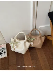 Elegante Damen Handtaschen mit Knitteroptik und Perlenanhänger auf Holzfaserboden