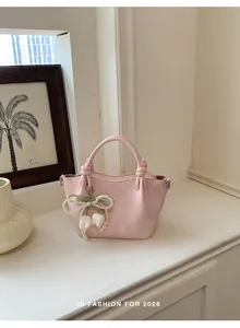 Nahaufnahme einer eleganten rosa Handtasche mit Tulpen-Perlenanhänger.