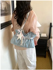 Elegante borsa tote blu plissettata con ciondolo a stella in un ambiente accogliente
