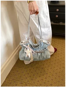 Vista dettagliata dell'elegante borsa tote in denim a pieghe con ciondolo a stella