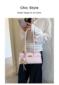 Detail view of pink faux leather tote bag with a cute teddy bear charm accessory