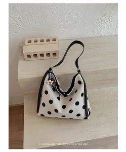 Bolso tote minimalista de lona con lunares negros clásicos sobre fondo blanco puro