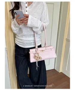Minimalist pink Korean style shoulder bag with cute bear charm carried by model