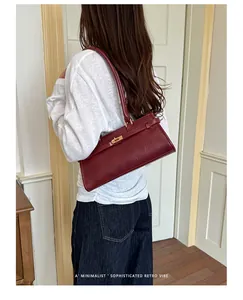Back view of model carrying a vintage burgundy baguette shoulder bag in minimalist style.