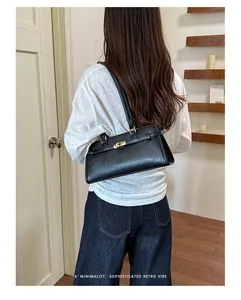 Minimalist black faux leather underarm tote bag with a sophisticated retro vibe