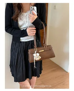 Model carrying a minimalist brown faux leather underarm tote bag in a retro vibe