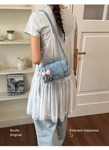 Back view of a model wearing a stylish light blue polka-dot crossbody bag with a pearl charm