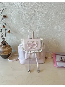 Nahaufnahme eines rosa Mini-Rucksacks im Vintage-Stil mit eleganter Spitze und einer Perlenherz-Dekoration