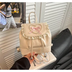 Detailansicht eines Mini-Vintage-Rucksacks mit Spitzenbesatz und Perlenherz-Dekoration