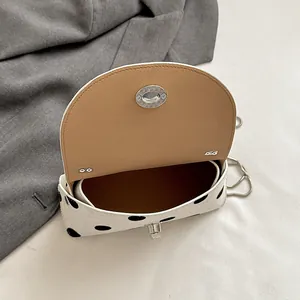 Gedetailleerde weergave van de open stijlvolle polkadot crossbodytas met beige voering