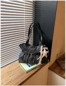 Vista dettagliata della borsa tote plissettata con ciondolo a stella e cinturino