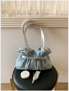 Vista dettagliata di una borsa tote plissettata celeste con manici e fibbia argentati