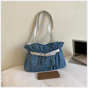 Elegante borsa a tracolla blu a pieghe con accenti argento in un set da ufficio
