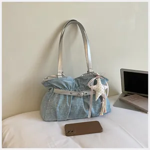 Dettaglio ravvicinato di una borsa a tracolla plissettata blu con spalline argento
