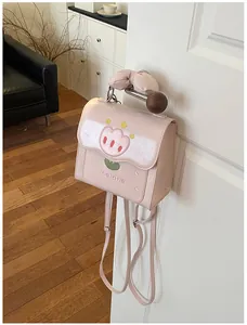 Gros plan d'un sac à dos rose en similicuir avec broderie tulipe et détail de nœud.