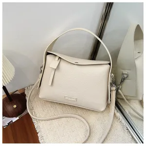 Close-up of cream lychee pattern handbag with elegant handle and mirror reflection